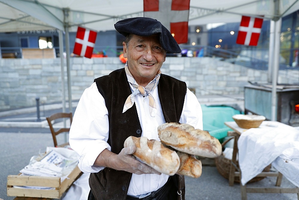 Baker with artisan bread, the agriculture fair (Comice Agricole) of Saint-Gervais-les-Bains, Haute Savoie, France, Europe