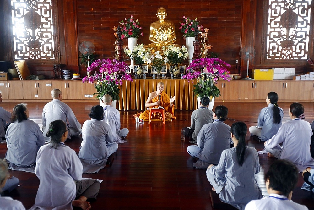 A teacher instructs a group of people how to recite Buddhist chants, Minh Dang Quang Buddhist Temple, Ho Chi Minh City, Vietnam, Indochina, Southeast Asia, Asia