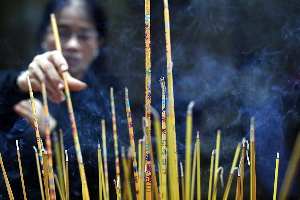 Mariamman Hindu Temple, woman burning incense sticks, Ho Chi Minh City. Vietnam, Indochina, Southeast Asia, Asia