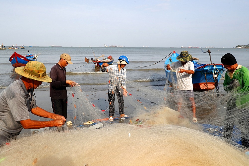 Fishermen repairing fishing nets at Tam Duong beach, Vung Tau, Vietnam, Indochina, Southeast Asia, Asia