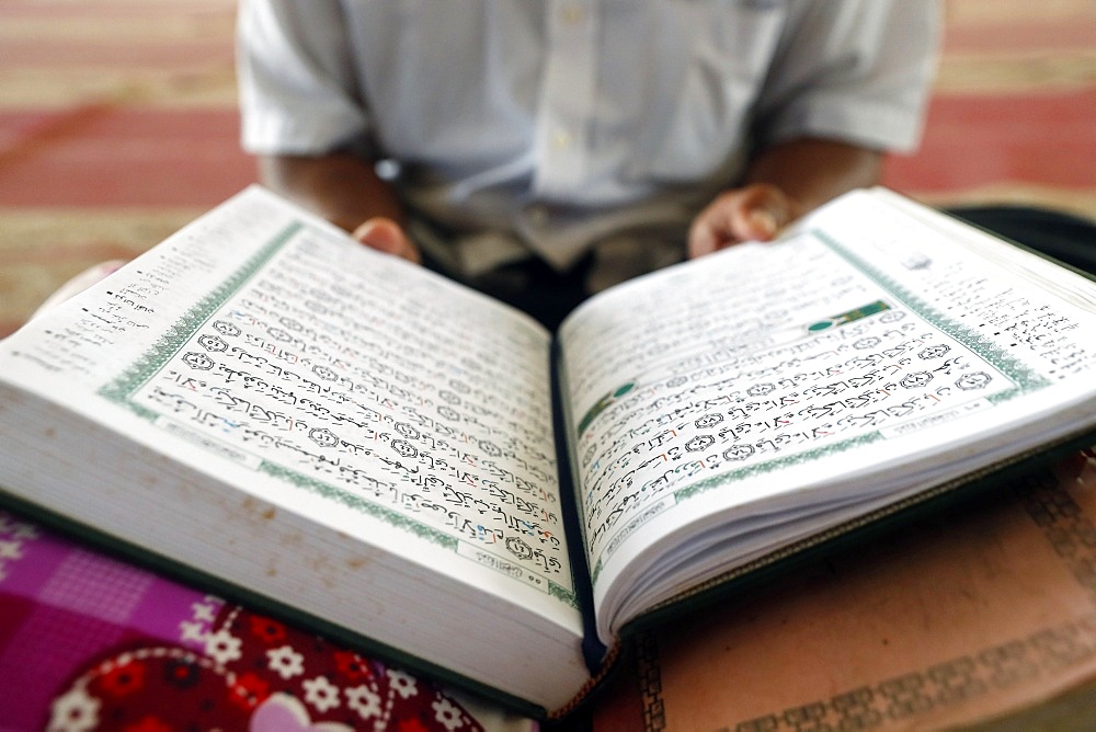 Old man reading Quran sitting on carpet in a mosque, Phnom Penh, Cambodia, Indochina, Southeast Asia, Asia