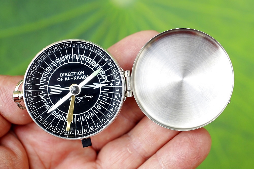 Close-up of a Muslim using a Qibla compass to indicate the direction of Al Kaaba, Cambodia, Indochina, Southeast Asia, Asia