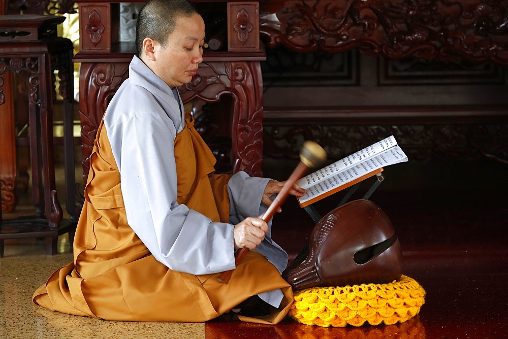 Buddhist ceremony at temple, monk playing on a wooden fish (percussion instrument), Ho Chi Minh City, Vietnam, Indochina, Southeast Asia, Asia