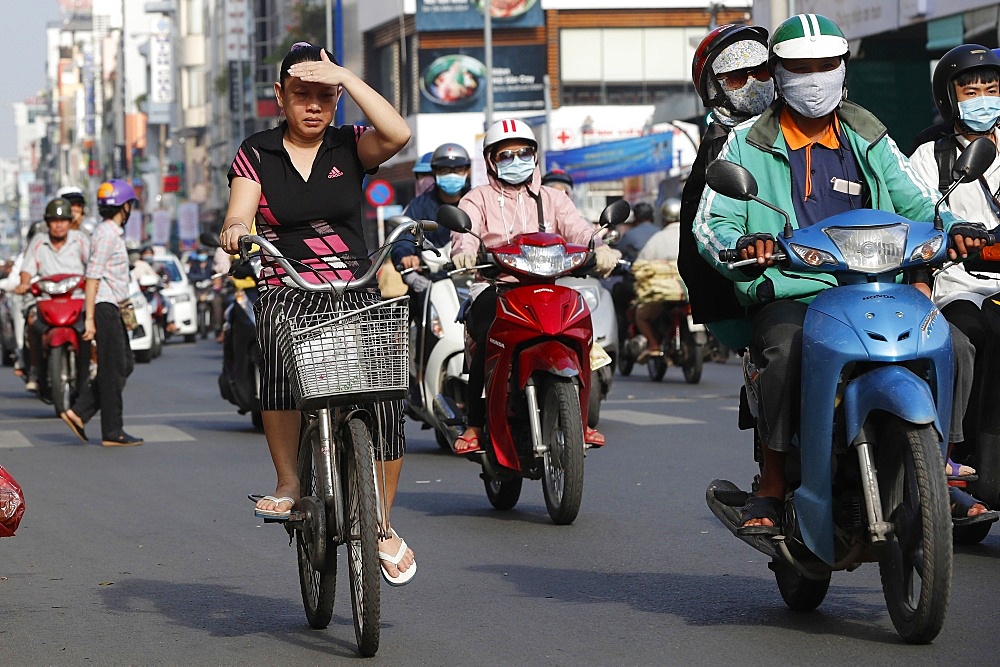 Bicycle and motorbikes on traffic road, Ho Chi Minh City, Vietnam, Indochina, Southeast Asia, Asia