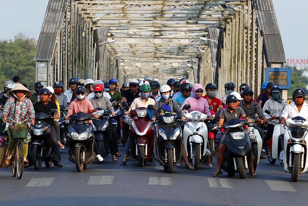 Scooters crossing the famous Trang Tien bridge in morning rush hour traffic, Hue, Vietnam, Indochina, Southeast Asia, Asia