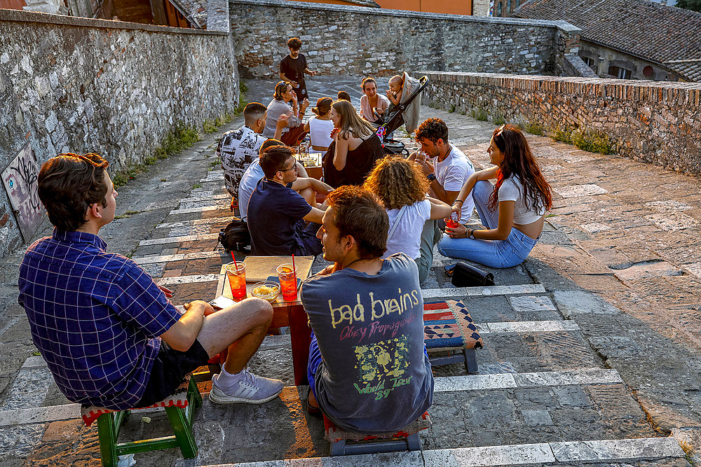 Young people sitting in a bar located on an urban staircase in Perugia, Umbria, Italy, Europe