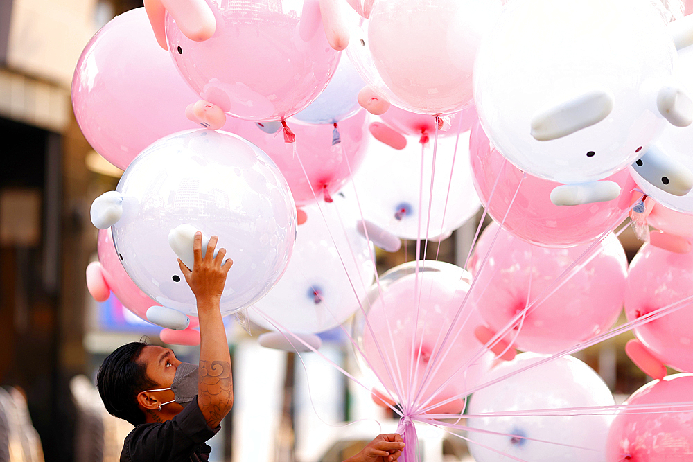 Man selling air pink balloon toys in street, Ho Chi Minh City, Vietnam, Indochina, Southeast Asia, Asia