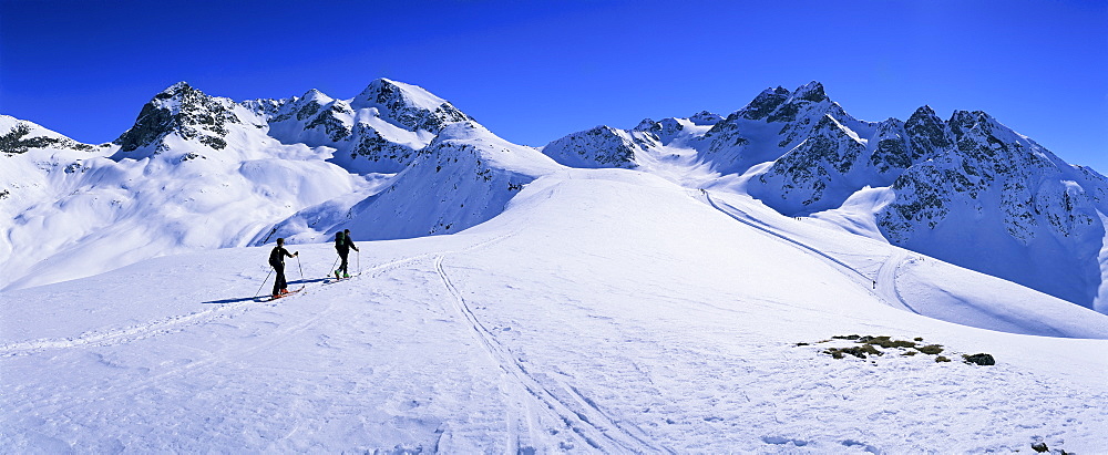 Alpine ski tourers start from Muottas Muragl at 2453m, with Philosopher's Walk on right, Pontresina, Engadine, Switzerland, Europe