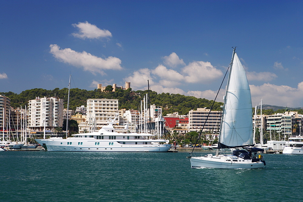 Yacht in Palma marina looking back to Castle de Bellver, Mallorca, Balearic Islands, Spain, Mediterranean, Europe