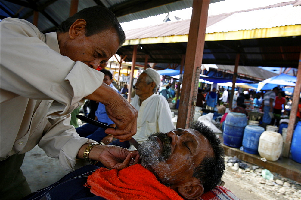 Barber at the market of Parapat, close to Lake Toba, Sumatra, Indonesia, Southeast Asia, Asia