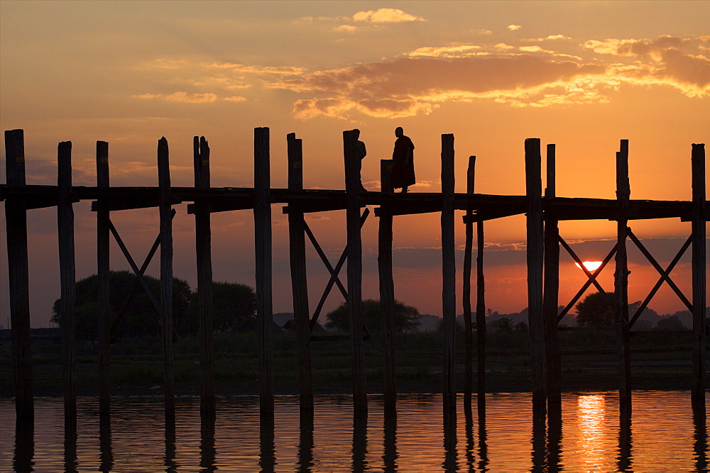 Cyclist on the U Bein teak bridge at sunset, Amarapura, Mandalay, Myanmar (Burma), Asia