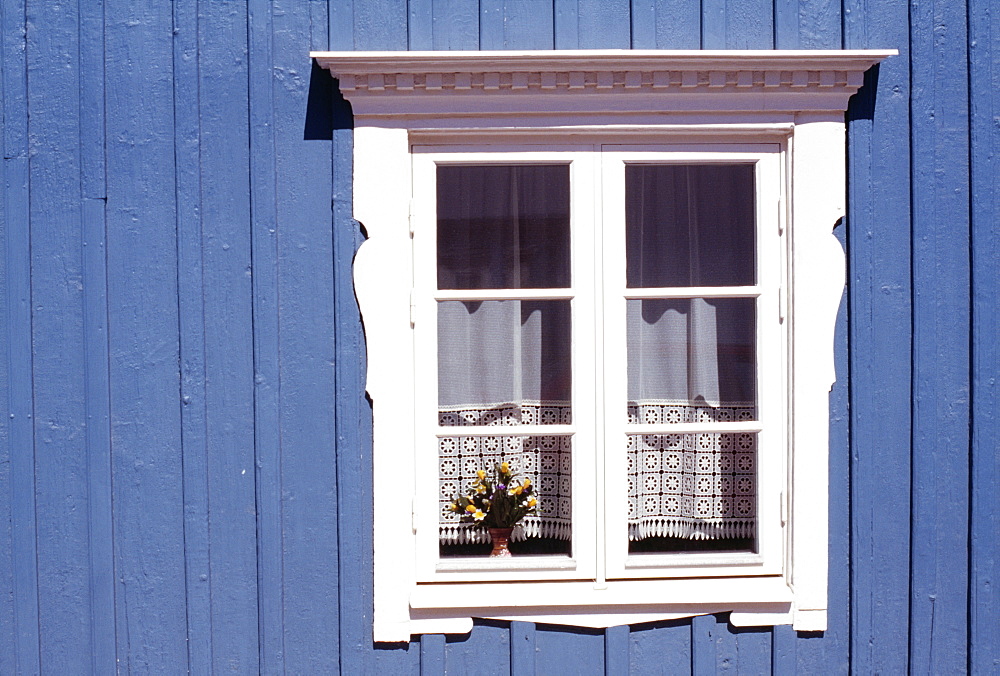 White window on blue wood clad house, traditional Swedish village style with crochet work curtain, Vimmerby, Smaland, Sweden, Scandinavia, Europe