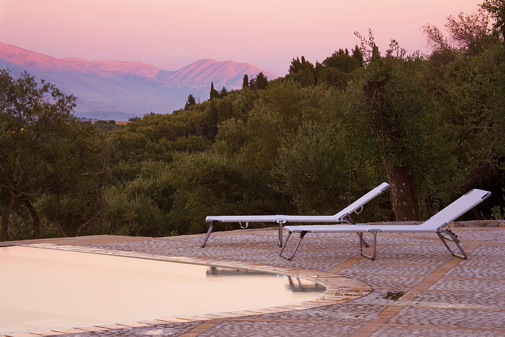 Sun loungers on pool terrace at sunset, Kerkyra, Corfu, Ionian Islands, Greek Islands, Greece, Europe