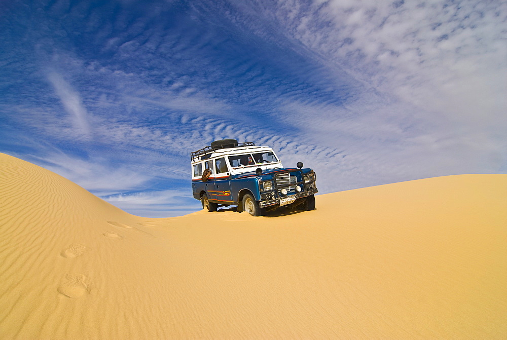 Jeep driving through the high sand dune of the Western Desert, near Siwa, Egypt, North Africa, Africa