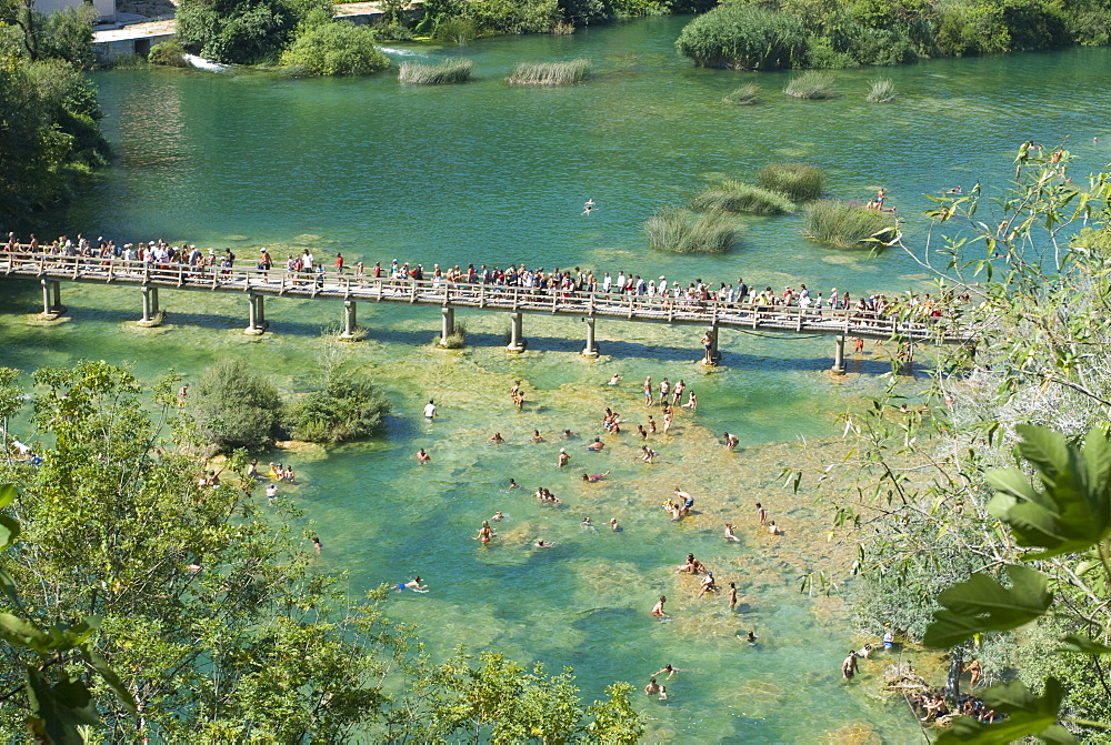 Bridge with many tourists above turquoise water in the Krka National Park, Croatia, Europe