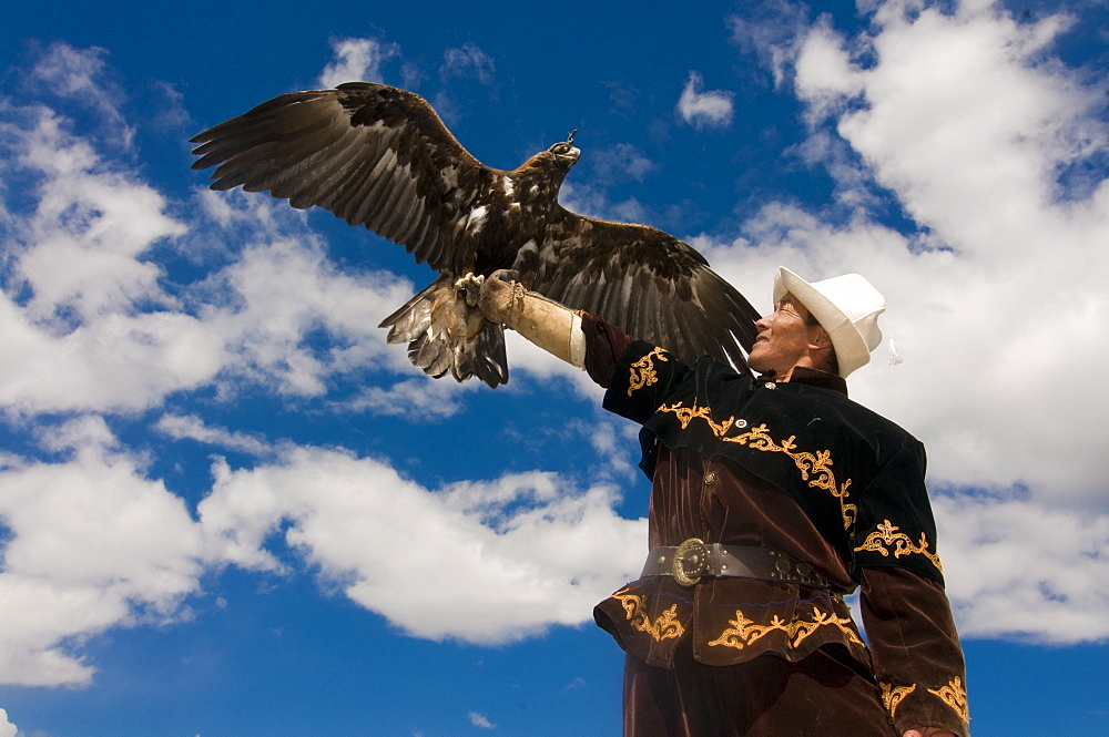 Eagle hunter with his golden eagle (Aquila chrysaetos) on his arm, Issyk Kol, Kyrgyzstan, Central Asia