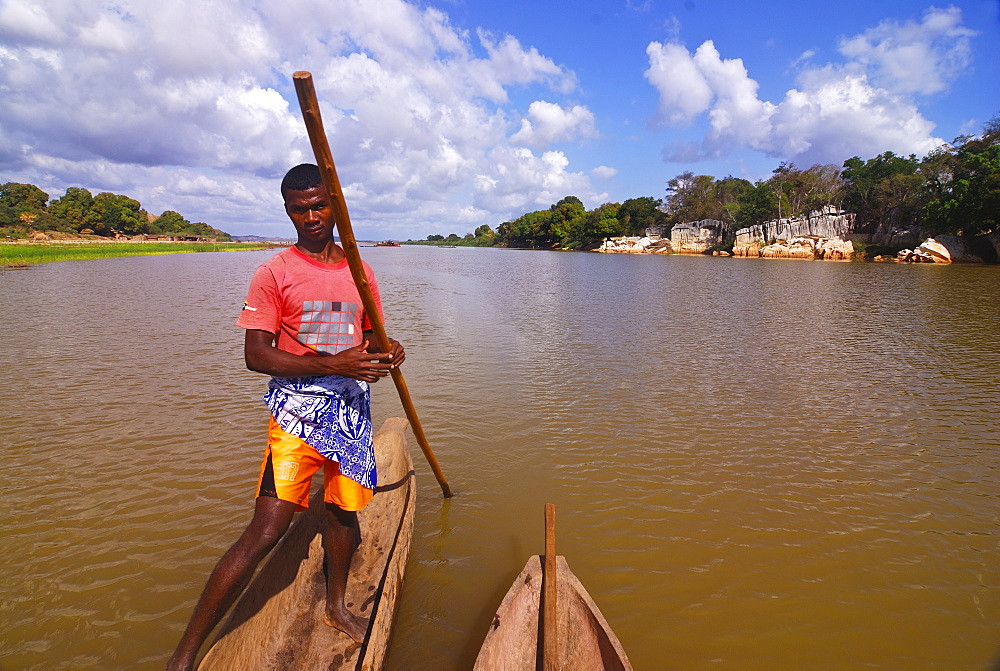 Young guide staking a canoe through the Manambolo river, Tsingy de Bemaraha, Madagascar, Africa