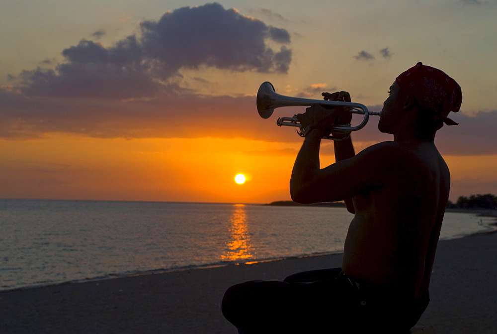 Trumpet player at sunset, Playa Ancon, Trinidad, Cuba, West Indies, Caribbean, Central America