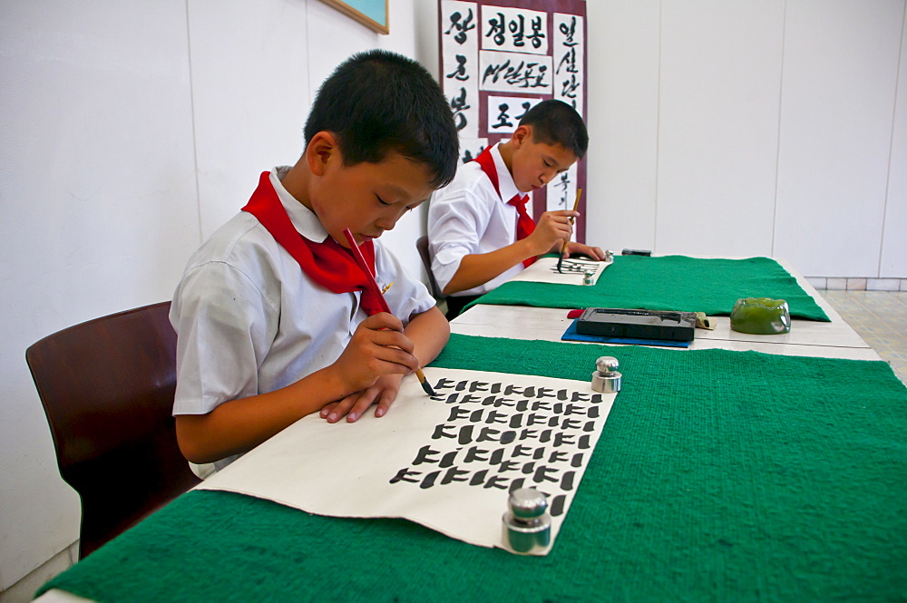 Young boys practising calligraphy in the Schoolchildrens palace, Pyongyang, North Korea, Asia