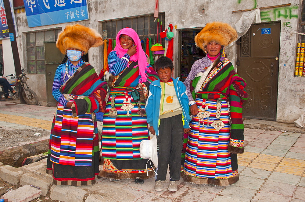 Traditionally dressed women and little boy at a market in Tsochen, Western Tibet, China, Asia