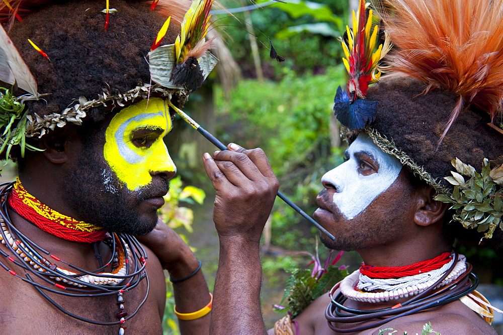 Tribesmen puting colour on their faces to celebrate the traditional Sing Sing in Paya in the Highlands, Papua New Guinea, Pacific