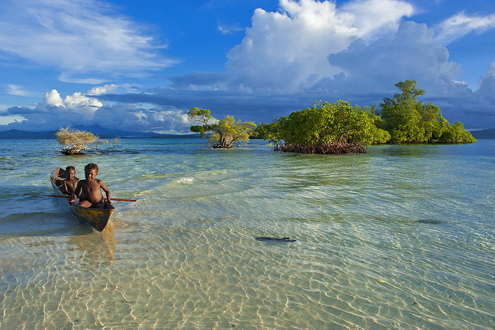 Young boys fishing in the Marovo Lagoon below dramatic clouds, Solomon Islands, Pacific