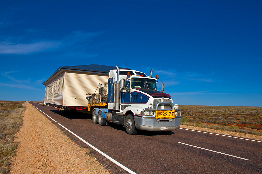 Truck transporting a full house on its trailer in the Outback of South Australia, Australia, Pacific