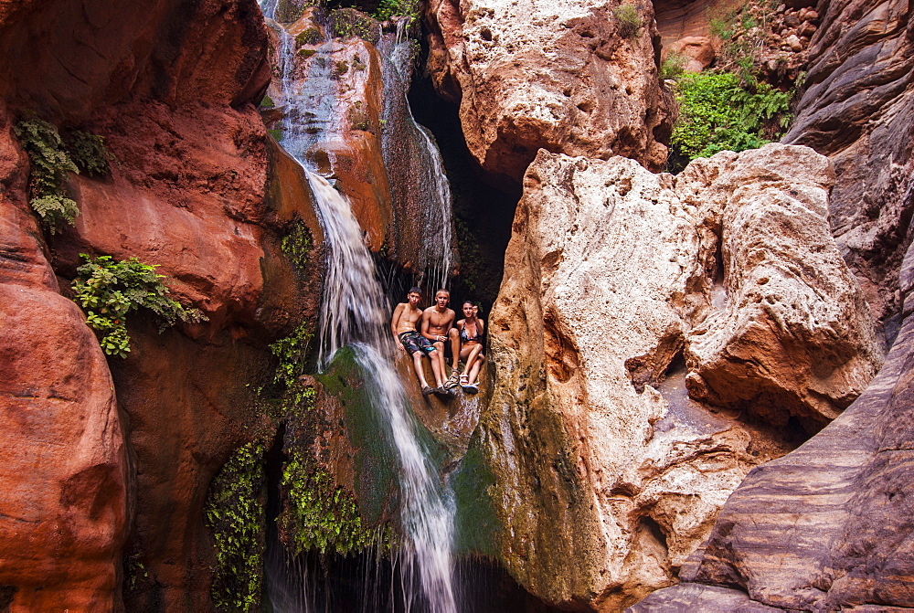 Tourists bathing in a waterfall, seen while rafting down the Colorado River, Grand Canyon, Arizona, United States of America, North America