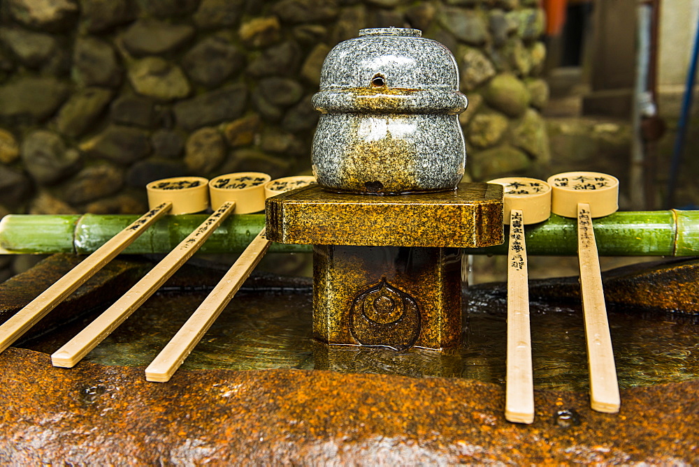 Water dipper in the Endless Red Gates of Kyoto's Fushimi Inarii Shrine, Kyoto, Japan, Asia