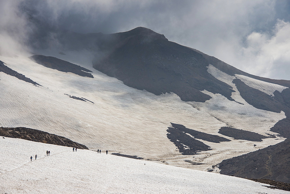 Tourists crossing a snowfield, Mutnovsky volcano, Kamchatka, Russia, Eurasia 