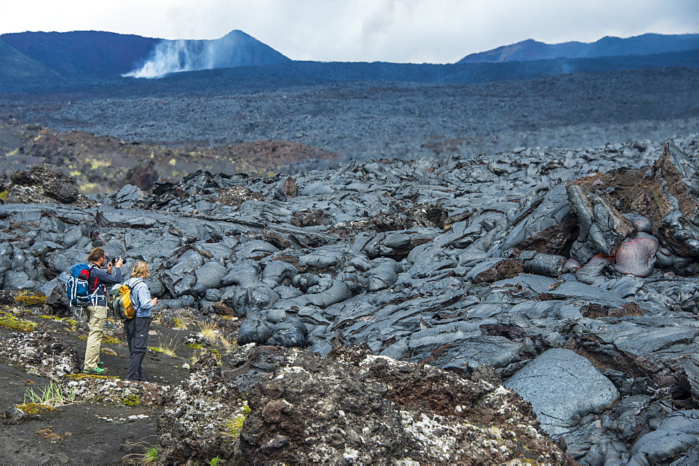 Tourists standing at a cold lava stream after an eruption of Tolbachik volcano, Kamchatka, Russia, Eurasia 