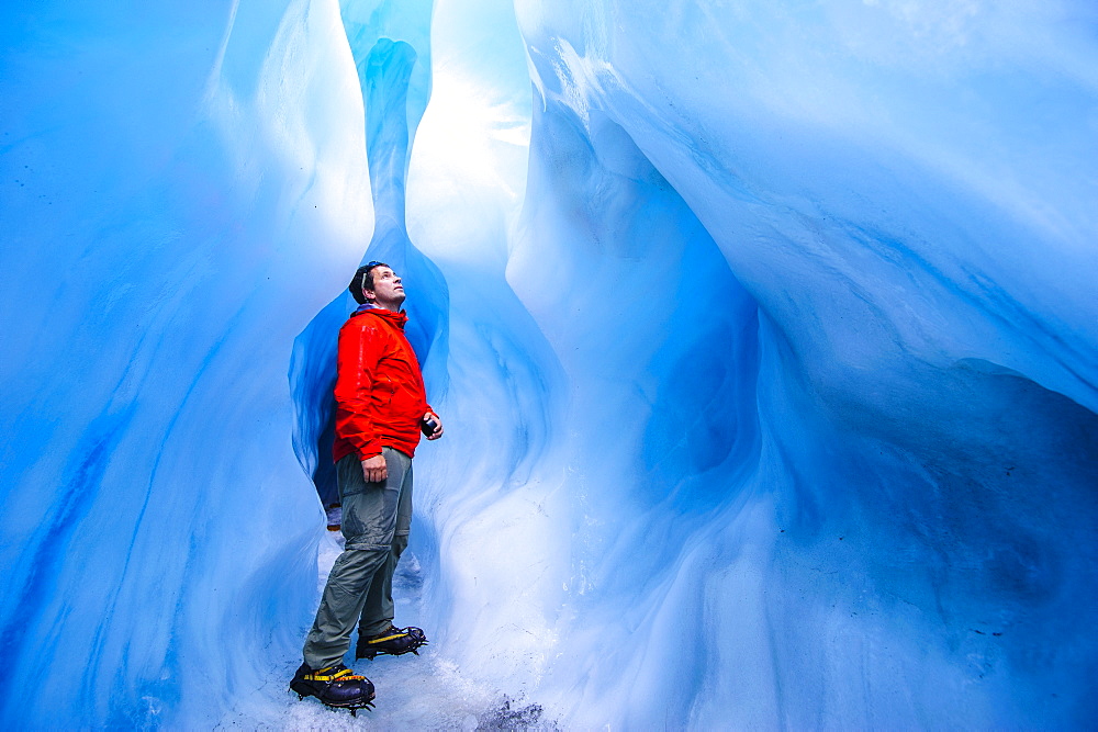 Man standing in an ice cave, Fox Glacier, Westland Tai Poutini National Park, South Island, New Zealand, Pacific