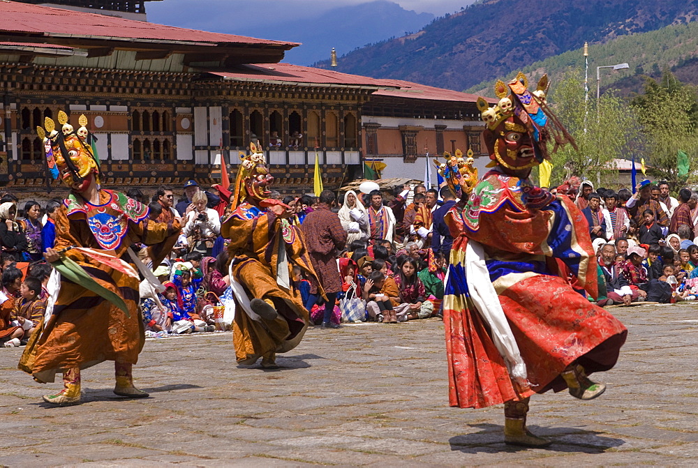 Costumed dancers at religious festival with many visitors, Paro Tsechu, Paro, Bhutan, Asia