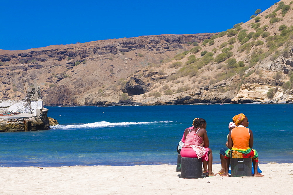 Two women sitting on the sandy beach talking, Tarrafal, Santiago, Cabo Verde, Africa