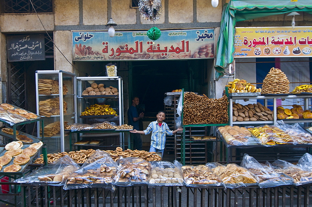 Young boy selling fresh bread in a bakery in the old part of Cairo, Egypt, North Africa, Africa