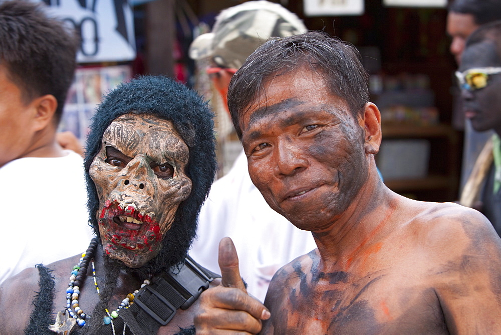 Portrait of two men, one masked, the other with soot smeared on his face during the Ati-Atihan Festival, an annual feast in honour of the Santo Nino, Boracay, Aklan, Philippines, Southeast Asia, Asia