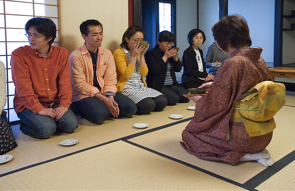 People receiving bowls of tea from the hostess at a Japanese tea ceremony, Japan, Asia