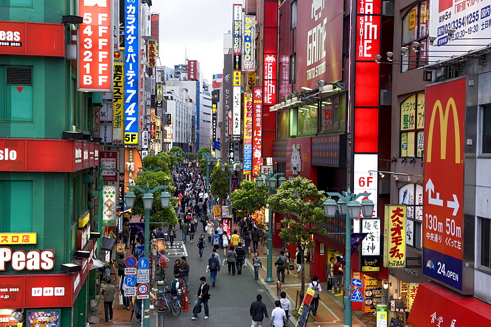 A pedestrian street lined with shops and signboards attracts a crowd in Shinjuku, Tokyo, Japan, Asia