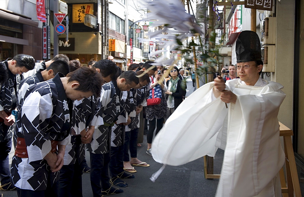 Shinto priest blessing a group of Sanja Festival participants in a religious ceremony in Asakusa, Tokyo, Japan, Asia