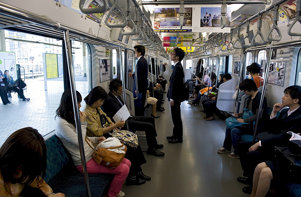 Passengers riding aboard the Yamanote loop line train that encircles greater metropolitan Tokyo, Japan, Asia