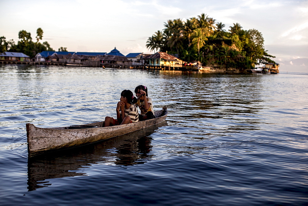 Two girls in a canoe, Togian Islands, Sulawesi, Indonesia, Southeast Asia, Asia