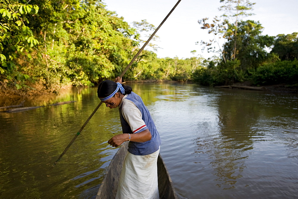 An Achuar man spear fishing on a tributary of the Amazon, Ecuador, South America