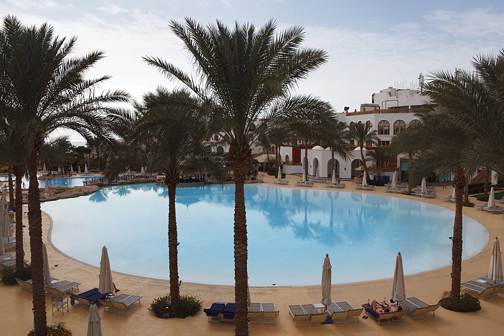 A palm fringed swimming pool within the Royal Savoy Resort at Sharm el-Sheikh, Egypt, North Africa, Africa