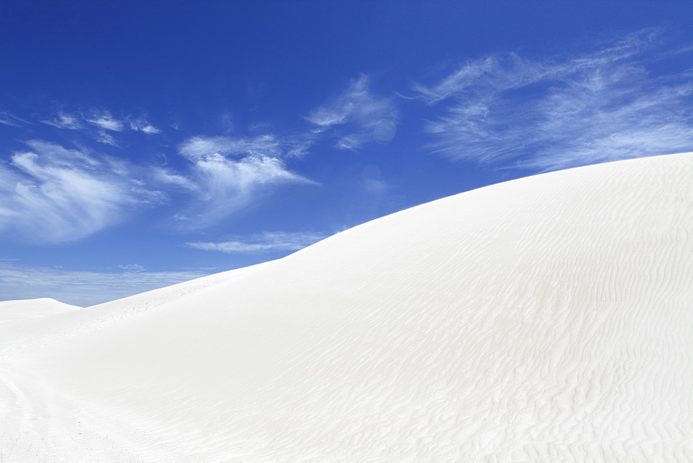 Wind blows white sand across the top on dune, under a blue sky, at Lancelin, Western Australia, Australia, Pacific