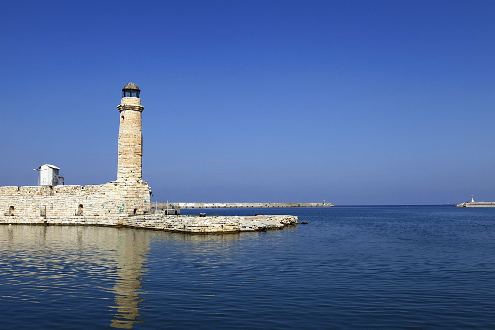 The Venetian era harbour walls and lighthouse at the Mediterranean port of Rethymnon, Crete, Greek Islands, Greece, Europe