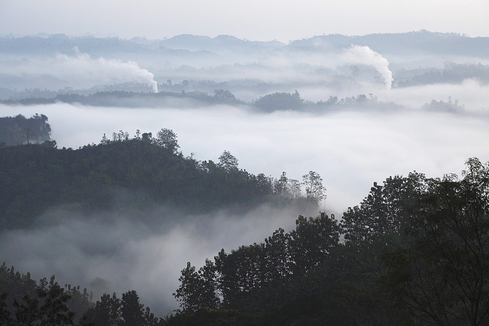 Early morning mist and smoke from brickworks in the valley over the jungle of Bandarban, Chittagong Division, Bangladesh, Asia