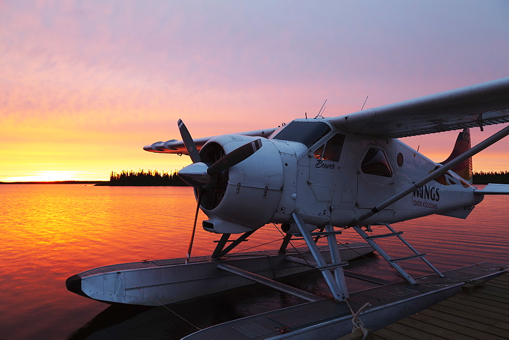 A float plane at the end of a jetty, at sunrise, in Egenolf Lake in northern Manitoba, Canada, North America