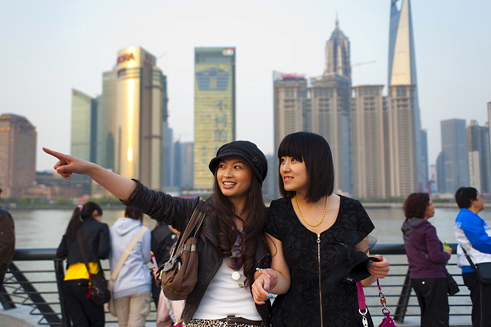 Tourists smiling and pointing, The Bund, Huangpu District, with Pudong District on the background, Shanghai, China, Asia