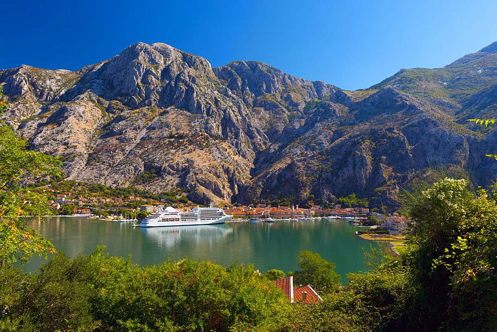 Cruise ship dwarfs the Old Town (Stari Grad), Kotor, Bay of Kotor, UNESCO World Heritage Site, Montenegro, Europe