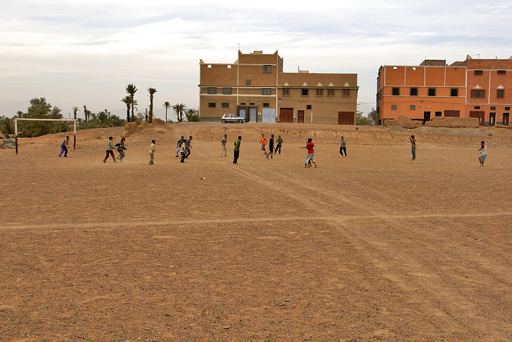 Moroccan children playing football outside a village in the Dades valley in Morocco